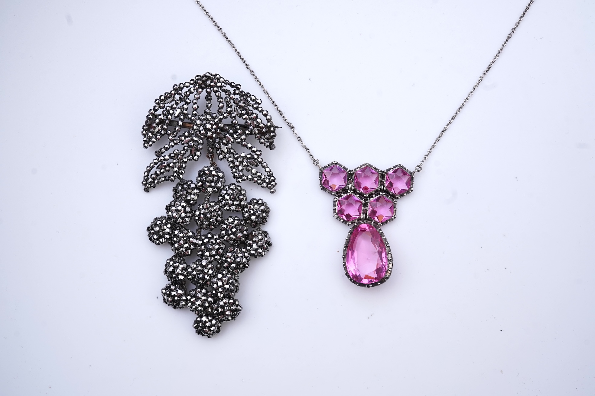 A cut steel brooch, 19th century, and a pink paste pendant